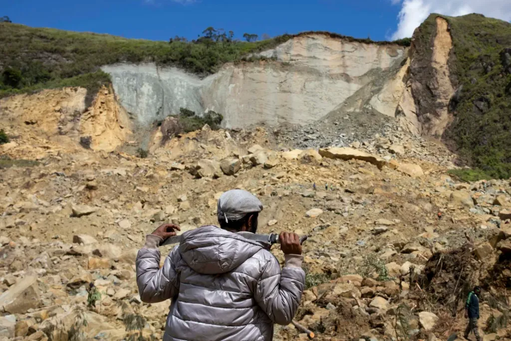 Residentes buscan personas sepultadas tras un deslizamiento de tierra en Yambali, Papúa Nueva Guinea