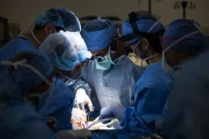 Cirujanos concentrados realizando un procedimiento quirúrgico complejo bajo luz focalizada en un quirófano hospitalario. trasplante