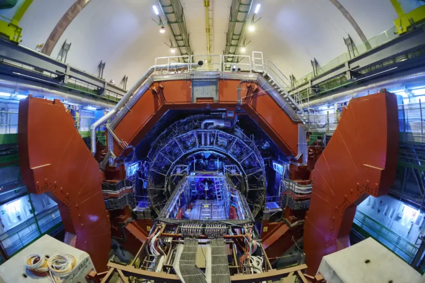 Vista frontal del detector ALICE en el Gran Colisionador de Hadrones del CERN, con estructuras metálicas, cables y luces azules activas.